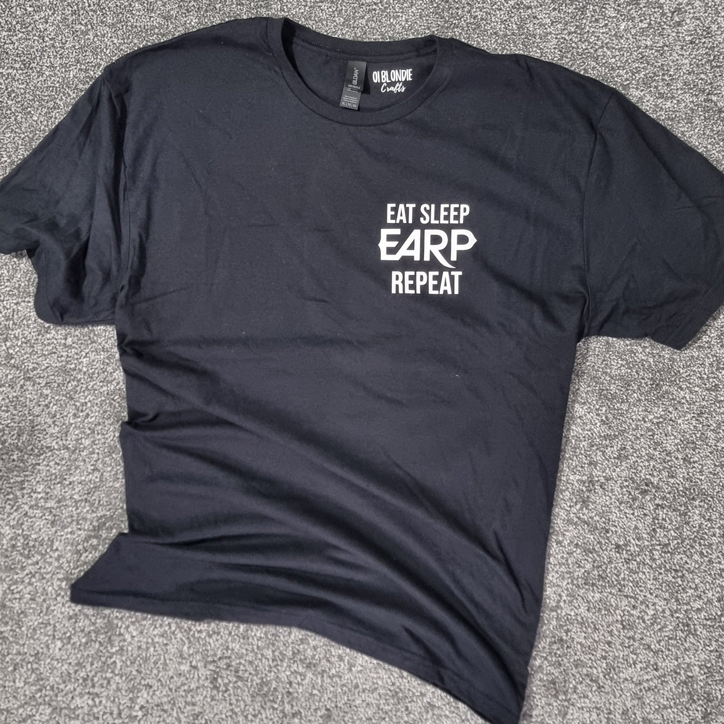 Black t-shirt with 'Eat Sleep EARP Repeat' text on a black surface