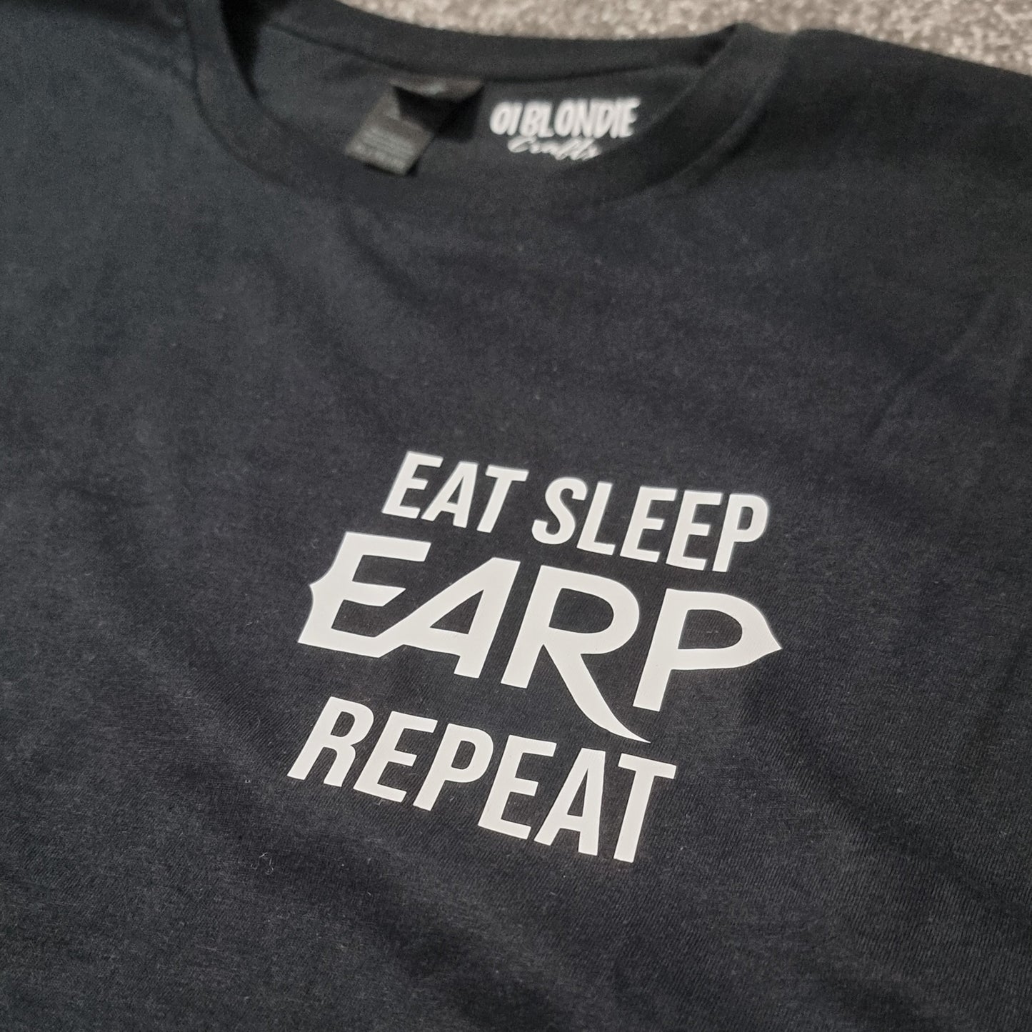 Black t-shirt with 'Eat Sleep EARP Repeat' text on a plain background