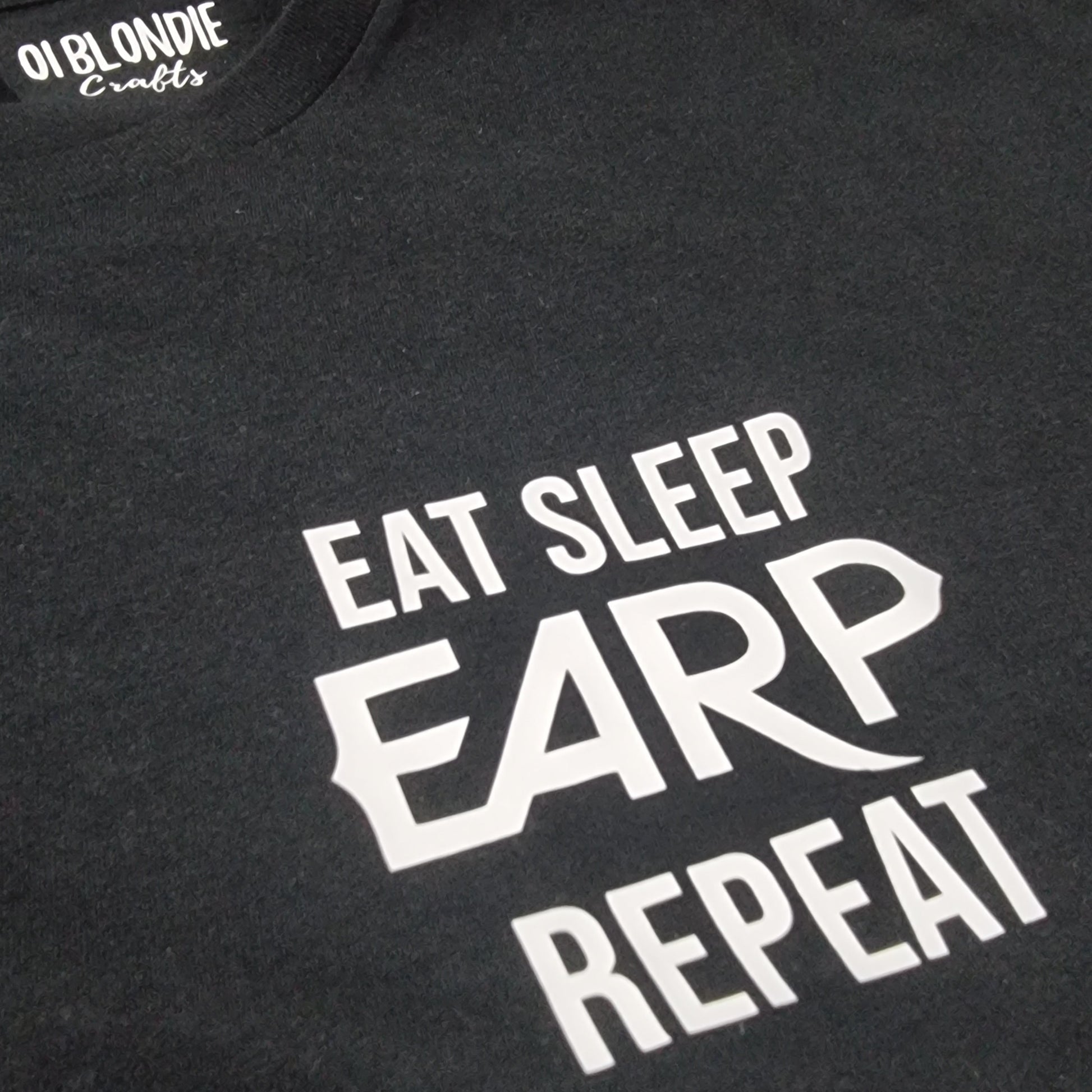 Black t-shirt with white text 'EAT SLEEP EARP REPEAT' on a dark background